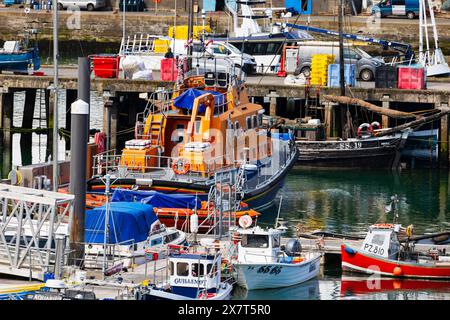 La nave di salvataggio Penlee, la RNLB Ivan Ellen e le barche da pesca nell'affollato porto di Newlyn, Cornovaglia, West Country, Inghilterra Foto Stock