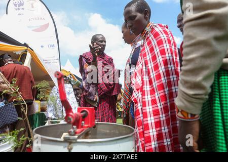 Gli allevatori locali di api Maasai chiedono informazioni sulle attrezzature per l'apicoltura esposte durante la giornata mondiale delle api. Associazioni locali di apicoltura in collaborazione con organizzazioni non governative ambientaliste (ONG) e il governo della contea, compresi agricoltori, studenti, ambientalisti, e i funzionari governativi si sono incontrati allo stadio Ildamat, nella contea di Kajiado in Kenya il 20 maggio 2024 per celebrare la giornata mondiale dell'ape e sensibilizzare i giovani e gli altri portatori di interessi sul ruolo essenziale delle api e degli altri impollinatori nell'agricoltura, nell'equilibrio ecologico e nella conservazione della biodiversità. Il tema della giornata Mondiale delle api Foto Stock