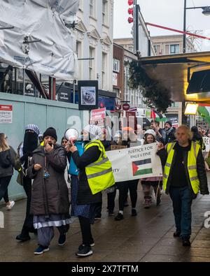 Un gruppo di persone che marciano durante la protesta pro Palestina, 16 dicembre 2023, Southampton, UKSeveral individui stanno tenendo dei cartelli con messaggi advo Foto Stock
