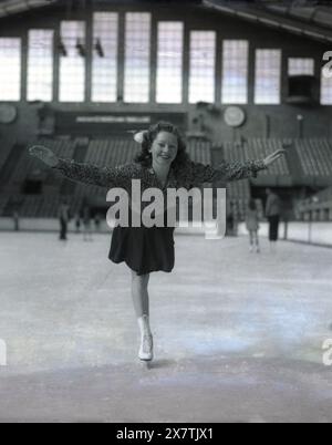 1939, storica, una giovane pattinatrice di figura sul ghiaccio presso l'Empress Hall di Earls Court, Inghilterra, Regno Unito, sede dei Campionati europei di pattinaggio di figura. Originariamente costruito alla fine degli anni '1880 come teatro, fu chiuso durante la prima guerra mondiale, riaprendo nel 1935 dopo essere stato convertito in una pista di pattinaggio su ghiaccio. Ora conosciuta come Empress Hall, nei due decenni successivi, la grande sede ospitò numerose stravaganze musicali su ghiaccio e eventi di pattinaggio, prima di chiudersi alla fine degli anni '1950 Foto Stock