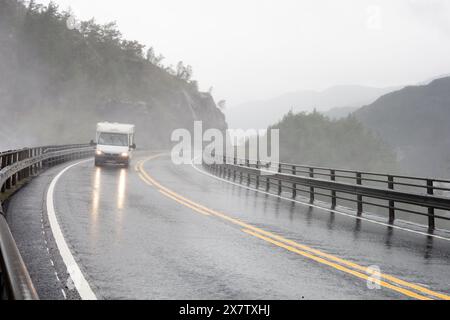 LANGFOSS, NORVEGIA - 9 AGOSTO 2016: Carovana bianca Fiat Ducato che guida in condizioni meteorologiche avverse sul ponte sotto la cascata Langfoss in Norvegia Foto Stock