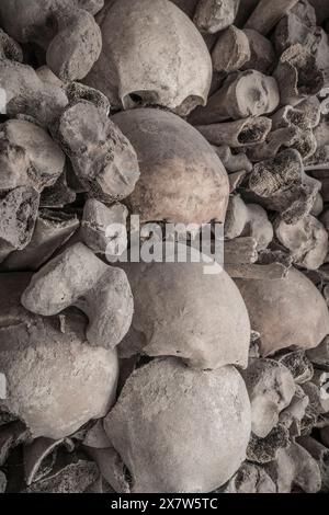 teschi e ossa impilati in una tomba Foto Stock
