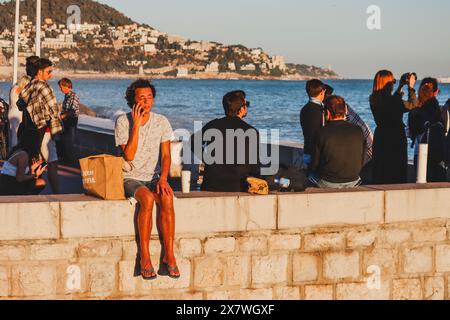 Nizza, Francia - 29.09.2022 : persone che ammirano il mare al tramonto, sul lungomare di Nizza Foto Stock
