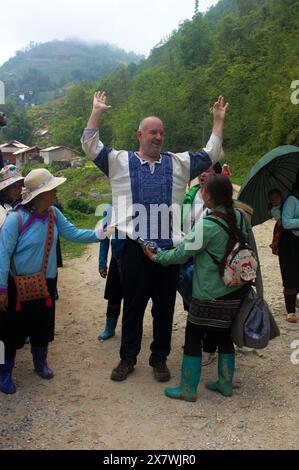 Un tizio caucasico viene molestato da donne locali per comprare souvenir, Cat Cat Village, Sapa, Lao Cai, Vietnam. Foto Stock