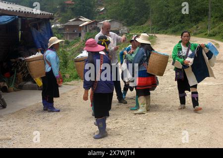 Un tizio caucasico viene molestato da donne locali per comprare souvenir, Cat Cat Village, Sapa, Lao Cai, Vietnam. Foto Stock