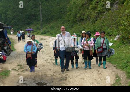 Un tizio caucasico viene molestato da donne locali per comprare souvenir, Cat Cat Village, Sapa, Lao Cai, Vietnam. Foto Stock