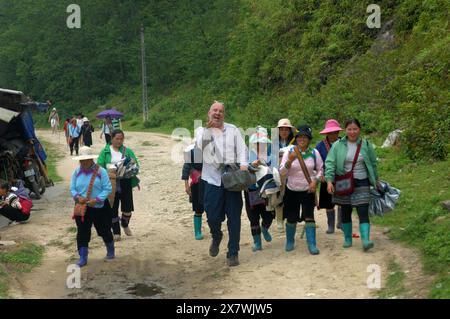 Un tizio caucasico viene molestato da donne locali per comprare souvenir, Cat Cat Village, Sapa, Lao Cai, Vietnam. Foto Stock