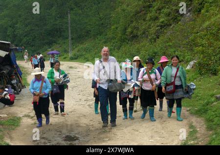 Un tizio caucasico viene molestato da donne locali per comprare souvenir, Cat Cat Village, Sapa, Lao Cai, Vietnam. Foto Stock