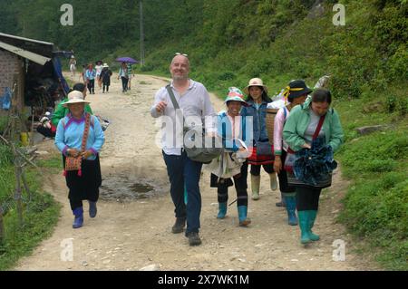 Un tizio caucasico viene molestato da donne locali per comprare souvenir, Cat Cat Village, Sapa, Lao Cai, Vietnam. Foto Stock