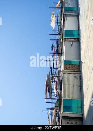 il bucato viene asciugato sulle linee. Vista da un'angolazione insolita. Balconi dei residenti locali. Vita asiatica. Foto Stock