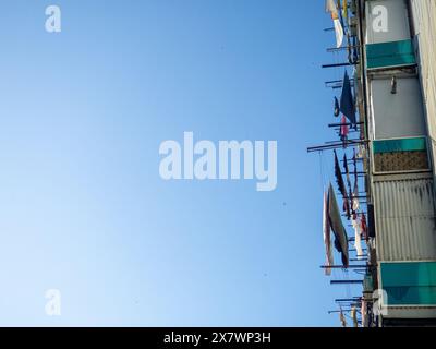 il bucato viene asciugato sulle linee. Vista da un'angolazione insolita. Balconi dei residenti locali. Vita asiatica. Foto Stock