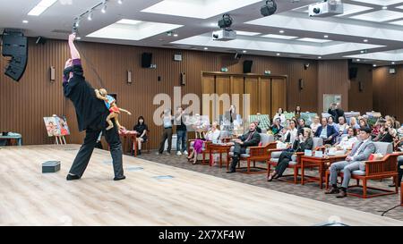 Belgrado, Serbia. 21 maggio 2024. Gli ospiti assistono a uno spettacolo durante la celebrazione della giornata Internazionale del tè presso il Centro culturale Cinese di Belgrado, Serbia, 21 maggio 2024. Circa 200 funzionari, studenti e amanti del tè si sono riuniti qui martedì per celebrare la quinta giornata internazionale del tè. Hanno goduto di un tradizionale spettacolo d'arte cinese del tè e hanno assaggiato l'Anxi Tieguanyin, una specialità di tè proveniente da Quanzhou, una città costiera nella provincia orientale del Fujian della Cina. Crediti: Wang Wei/Xinhua/Alamy Live News Foto Stock