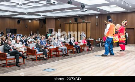 Belgrado, Serbia. 21 maggio 2024. Gli ospiti assistono a uno spettacolo durante la celebrazione della giornata Internazionale del tè presso il Centro culturale Cinese di Belgrado, Serbia, 21 maggio 2024. Circa 200 funzionari, studenti e amanti del tè si sono riuniti qui martedì per celebrare la quinta giornata internazionale del tè. Hanno goduto di un tradizionale spettacolo d'arte cinese del tè e hanno assaggiato l'Anxi Tieguanyin, una specialità di tè proveniente da Quanzhou, una città costiera nella provincia orientale del Fujian della Cina. Crediti: Wang Wei/Xinhua/Alamy Live News Foto Stock