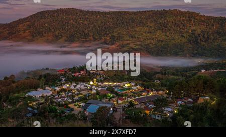 Un'attrazione turistica in Thailandia chiamata Khao Kho è raffigurata all'alba con la nebbia che galleggia su un piccolo villaggio, la provincia di Phetchabun in Thailandia. Foto Stock