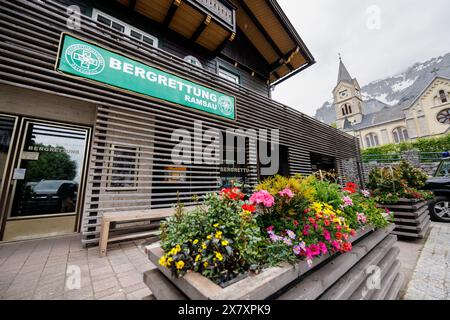 Ramsau am Dachstein, Austria. 21 maggio 2024. La scritta "Bergrettungsdienst sterreich - Bergrettung Ramsau" può essere vista su 21.05.2024 durante le riprese sul set della serie televisiva "Die Bergretter" presso il fittizio centro operativo della "Bergrettungsdienst Ortsstelle Ramsau am Dachstein" presso la location delle riprese a Ramsau am Dachstein in Stiria (Austria). La chiesa protestante è sullo sfondo. Le riprese della sedicesima stagione dei soccorritori di montagna sono in corso da febbraio - i nuovi episodi saranno trasmessi nell'autunno 2024. Crediti: Matthias Balk/dpa/Alamy Live News Foto Stock