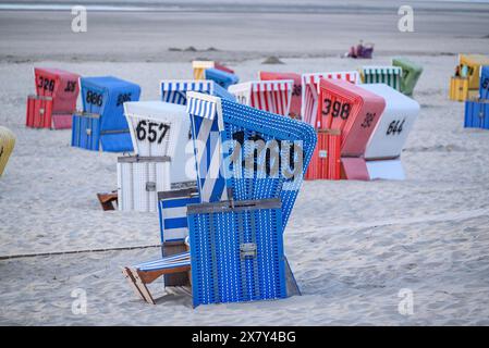 Tranquilla atmosfera estiva sulla spiaggia con sedie colorate e sabbia soffice, molte sedie colorate in spiaggia in una calda serata estiva in riva al mare, l Foto Stock