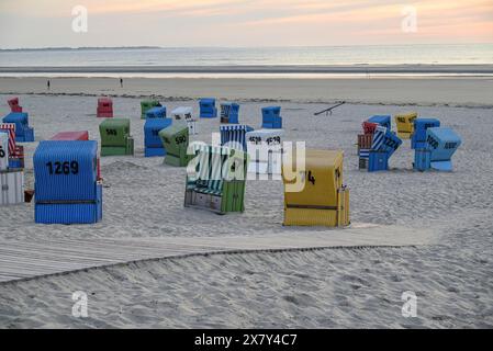 Una fresca serata in spiaggia con sedie colorate, un passaggio pedonale in legno e un'atmosfera tranquilla, molte sedie colorate in una mite serata estiva Foto Stock