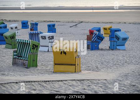 Una tranquilla e rilassante serata in spiaggia con sedie colorate, un passaggio pedonale in legno e sabbia soffice, molte sedie colorate in un clima mite di eveni estivi Foto Stock