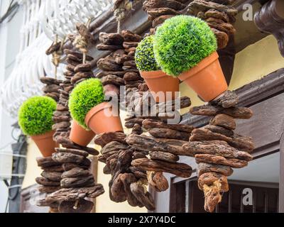 Decorazioni rustiche con vasi di fiori e piante in pentole di terracotta davanti ad una porta in legno, balcone in legno con decorazioni floreali sulla storica Foto Stock