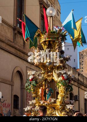 Una struttura dorata finemente decorata con statue e bandiere colorate, situata in un ambiente urbano in una giornata di sole, Catania, italia, 3 febbraio 2 Foto Stock