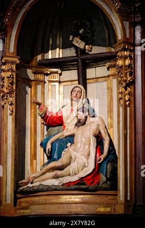 Iglesia San Nicolas de Bari, Una scultura barocca della Pietà, mostra Maria in lutto che tiene in braccio Gesù morto, circondata da dettagli dorati, Old T Foto Stock