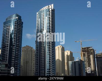 Diversi moderni grattacieli si innalzano nel cielo limpido, alcuni edifici in costruzione, l'impressionante skyline di una città moderna con uno spettacolare grattacielo Foto Stock