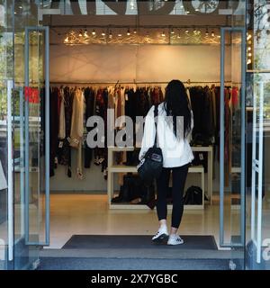 Donna che entra nella boutique di abbigliamento elegante nel centro di Bucarest, Romania il 15 ottobre 2023 Foto Stock