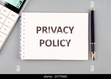 Testo dell'Informativa sulla privacy scritto su un quaderno bianco su sfondo grigio Foto Stock