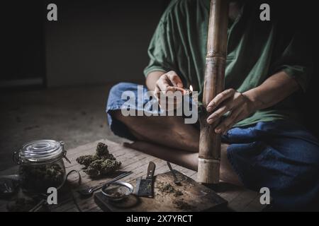 Un uomo prepara marijuana su un tagliere per fumare, persona che fuma droga, tossicodipendenza, tossicodipendenza e sintomi di astinenza. DrugsInte Foto Stock