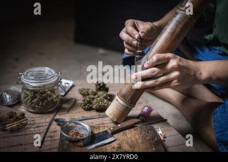 Un uomo prepara marijuana su un tagliere per fumare, persona che fuma droga, tossicodipendenza, tossicodipendenza e sintomi di astinenza. DrugsInte Foto Stock