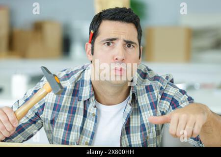 l'uomo ha toccato un dito con un martello Foto Stock