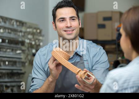 processo di lavoro della cintura di pelle in officina Foto Stock