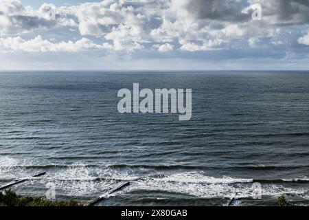 Vista costiera del Mar Baltico con frangiflutti e acque costiere sotto il cielo nuvoloso tempestoso di giorno. Paesaggio di Svetlogorsk, Oblast' di Kaliningrad, Russia Foto Stock