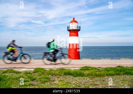 Diga del Mare del Nord vicino a Westkapelle, faro di Westkapelle Laag, ciclisti sulla pista ciclabile Zeeuwse Wind Route, provincia della Zelanda, penisola di Walcheren, Foto Stock