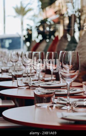 Tavoli disposti su una terrazza del ristorante con palme sullo sfondo Foto Stock