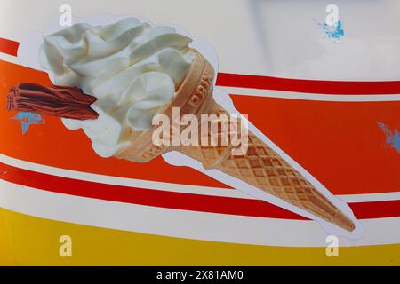 Strati sovrapposti di vinile colorato e grafica stampata creano un furgone da gelato Mr Whippy completamente livato, parcheggiato con vista sul mare nell'aprile 2024. Foto Stock
