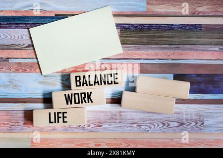 WORK LIFE BALANCE - parole su blocchi di legno su sfondo vintage, accanto a un blocco note per scrivere Foto Stock