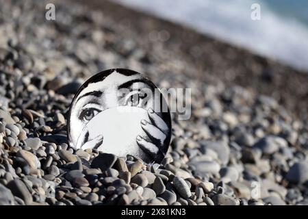 Piatto Fornasetti sulla spiaggia di ciottoli, il volto appartiene alla cantante lirica italiana Lina Cavalieri Foto Stock