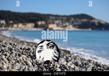 Piatto Fornasetti sulla spiaggia di ciottoli, il volto appartiene alla cantante lirica italiana Lina Cavalieri Foto Stock