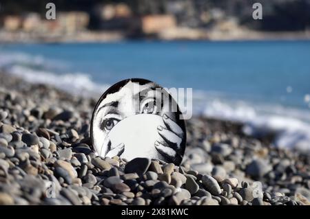 Piatto Fornasetti sulla spiaggia di ciottoli, il volto appartiene alla cantante lirica italiana Lina Cavalieri Foto Stock