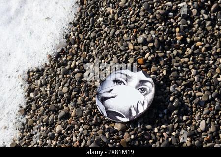 Piatto Fornasetti sulla spiaggia di ciottoli, il volto appartiene alla cantante lirica italiana Lina Cavalieri Foto Stock