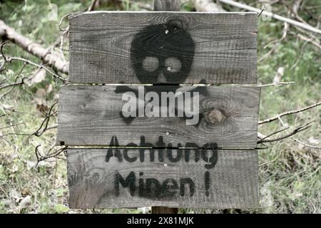 Cartello di legno con l'iscrizione "Achtung Minen". Fate attenzione, mine. Foto Stock