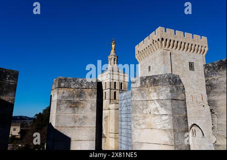 Osservata attraverso le merlature di una torre vicina, la statua dorata della vergine maria brilla brillantemente ad Avignone sotto un vasto e limpido cielo blu profondo. Foto Stock