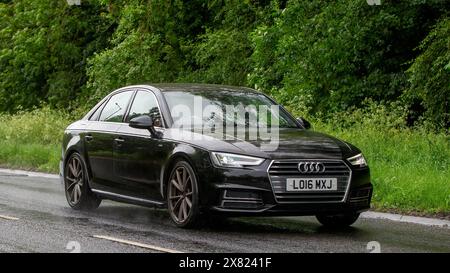 Stony Stratford, Regno Unito - 22 maggio 2024: 2016 motore diesel nero Audi A4 che guida su una strada britannica in una giornata di pioggia Foto Stock