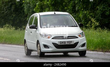 Stony Stratford, Regno Unito - 22 maggio 2024: 2011 auto Hyundai i10 bianca che guida su una strada britannica in una giornata umida Foto Stock