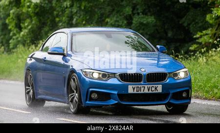 Stony Stratford, Regno Unito - 22 maggio 2024: Auto blu 2017 BMW 420 diesel che guida su una strada britannica in una giornata di pioggia Foto Stock