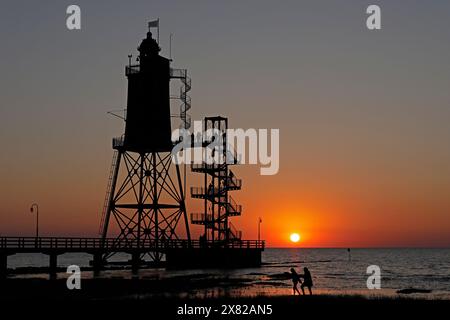 Tramonto, faro Obereversand, sagome, persone, Mare del Nord, Dorum-Neufeld, Wurster Land, bassa Sassonia, Germania Foto Stock