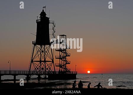 Tramonto, faro Obereversand, sagome, persone, Mare del Nord, Dorum-Neufeld, Wurster Land, bassa Sassonia, Germania Foto Stock