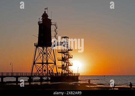 Tramonto, faro Obereversand, sagome, persone, Mare del Nord, Dorum-Neufeld, Wurster Land, bassa Sassonia, Germania Foto Stock