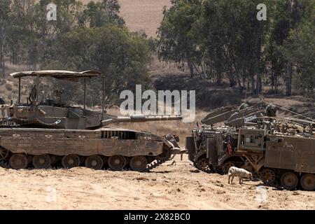 Israele meridionale, Israele. 22 maggio 2024. Un carro armato dell'esercito israeliano e diversi vettori armati (APC) come cane vagano in un'area di sosta avanzata all'interno del sud di Israele vicino al confine con la Striscia di Gaza il 22 maggio 2024. Il giorno in cui Spagna, Irlanda e Norvegia hanno annunciato che avrebbero riconosciuto uno Stato palestinese la prossima settimana Israele riferisce che tre dei suoi soldati sono stati uccisi nella battaglia di Hamas nella Striscia di Gaza settentrionale. Foto di Jim Hollander/UPI credito: UPI/Alamy Live News Foto Stock